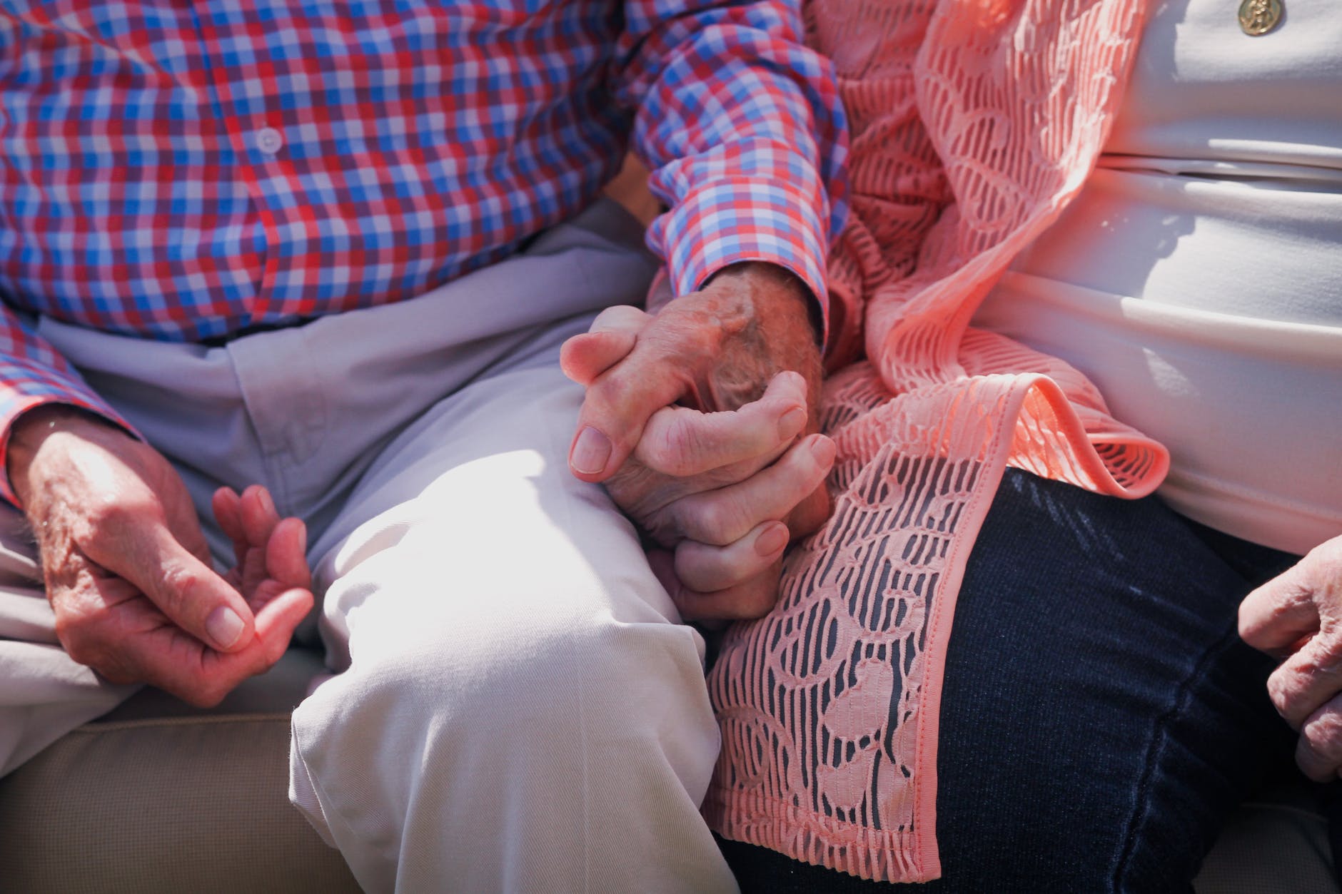 crop elderly couple holding hands gently